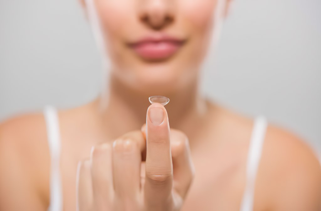 Woman holding a contact lens on her finger.